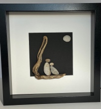 Couple on driftwood, with moon